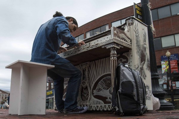 IMAGE: October 4, 2013 CAMBRIDGE -- Fabio Tedde plays a public piano in Brattle Square on Friday afternoon. There are 75 pianos across Boston for Luke Jerram’s “Play Me, I’m Yours” exhibit, which has put temporary street pianos in over thirty cities in the past five years. Tedde, an Italian street performer, follows the piano exhibits and tries to play them all -- this his 38th in Boston and his 434th worldwide. (Photo by Poncie Rutsch.)