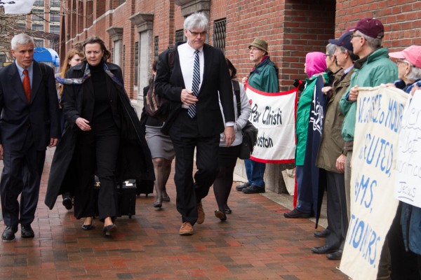 Boston. Apr.21, 2015. Members of the Tsarnaev defense team arrive at the John Joseph Moakley United States Courthouse on the first day of the sentencing phase as they walk past protestors who oppose death penalty. Tsarnaev, who was found guilty by the jury of all 30 charges against him, will either serve a life in prison without the possibility of a release or receive a death sentence. (Photo by: Haiyun Jiang/BU News Service)
