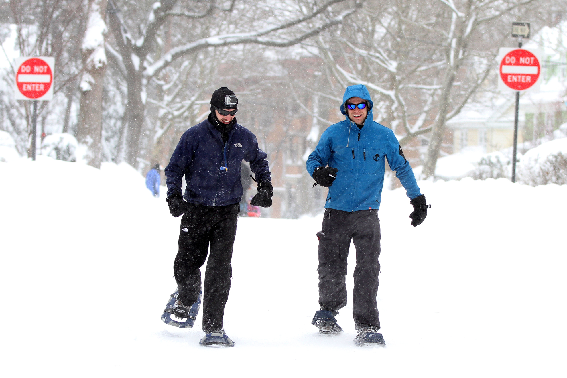 Image: Brookline residents Thomas Battey (left) and Vincent Valant walk with snowshoes down Fuller Street on Saturday after a winter storm passed through the Northeast, leaving over 20 inches of snow in the city of Boston. (Photo by Billie Weiss/BU News Service)