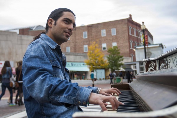 IMAGE: October 4, 2013 CAMBRIDGE -- Fabio Tedde plays a public piano in Brattle Square on Friday afternoon. There are 75 pianos spread across Boston for Luke Jerram’s “Play Me, I’m Yours” exhibit. Tedde, an Italian street performer, follows the piano exhibits and tries to play them all. “99 percent of the time I improvise,” Tedde says, explaining that he used to read music but has long forgotten how. (Photo by Poncie Rutsch.)