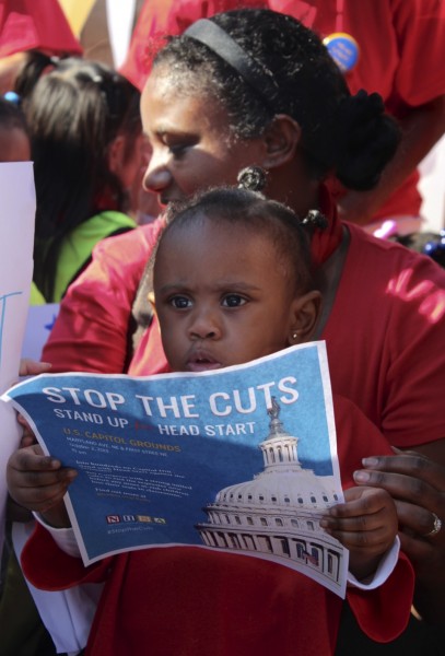 IMAGE: Children stand in front of the Capitol on Oct. 2, 2013 during a rally urging the government to halt spending cuts to Head Start. (Photo: Taylor Hartz, BU News Service)